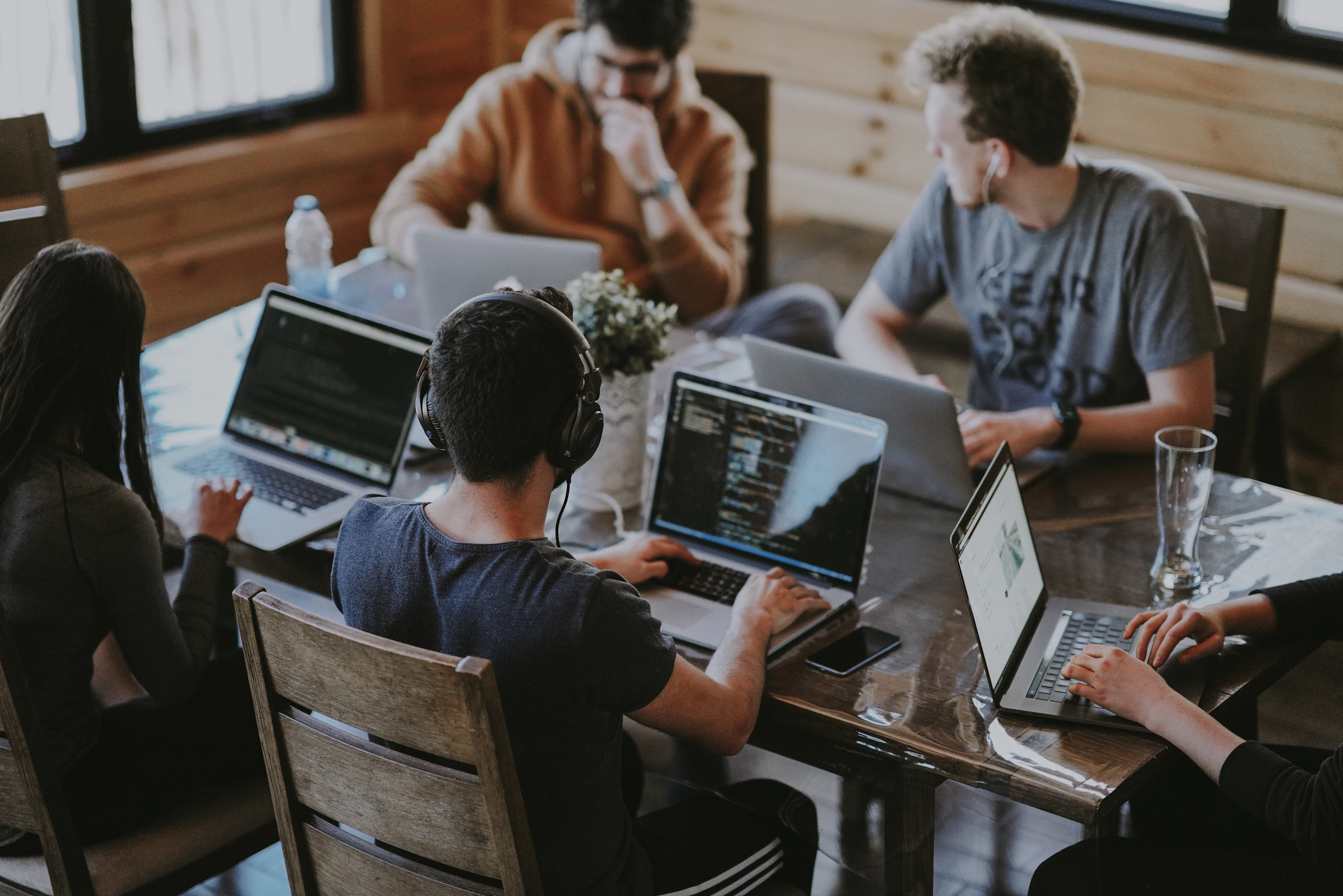 A team of developers working on laptops around a table