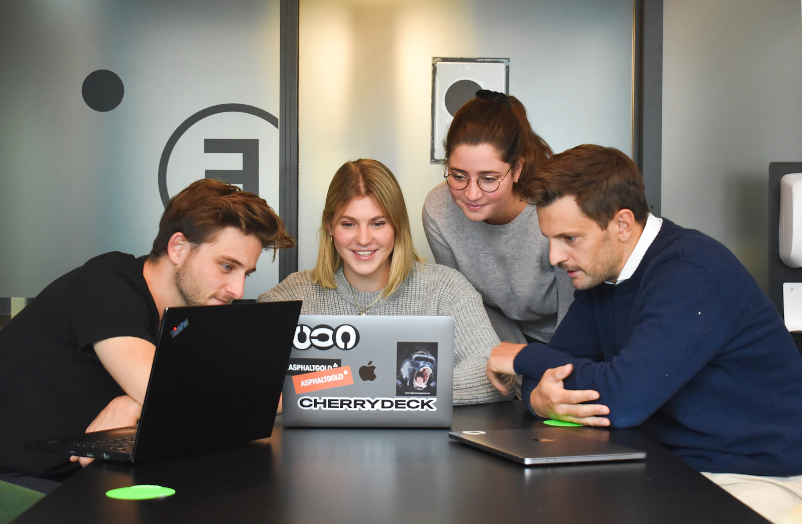 A team gathered around a laptop, working together
