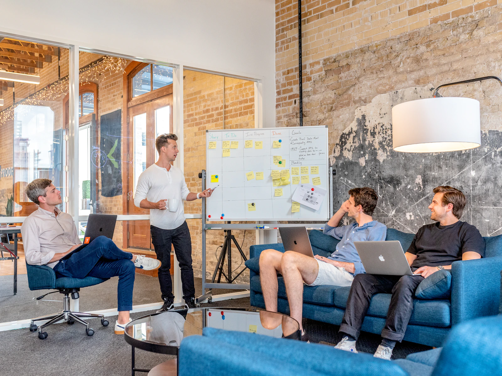 A team discussing a plan in front of a whiteboard covered in notes