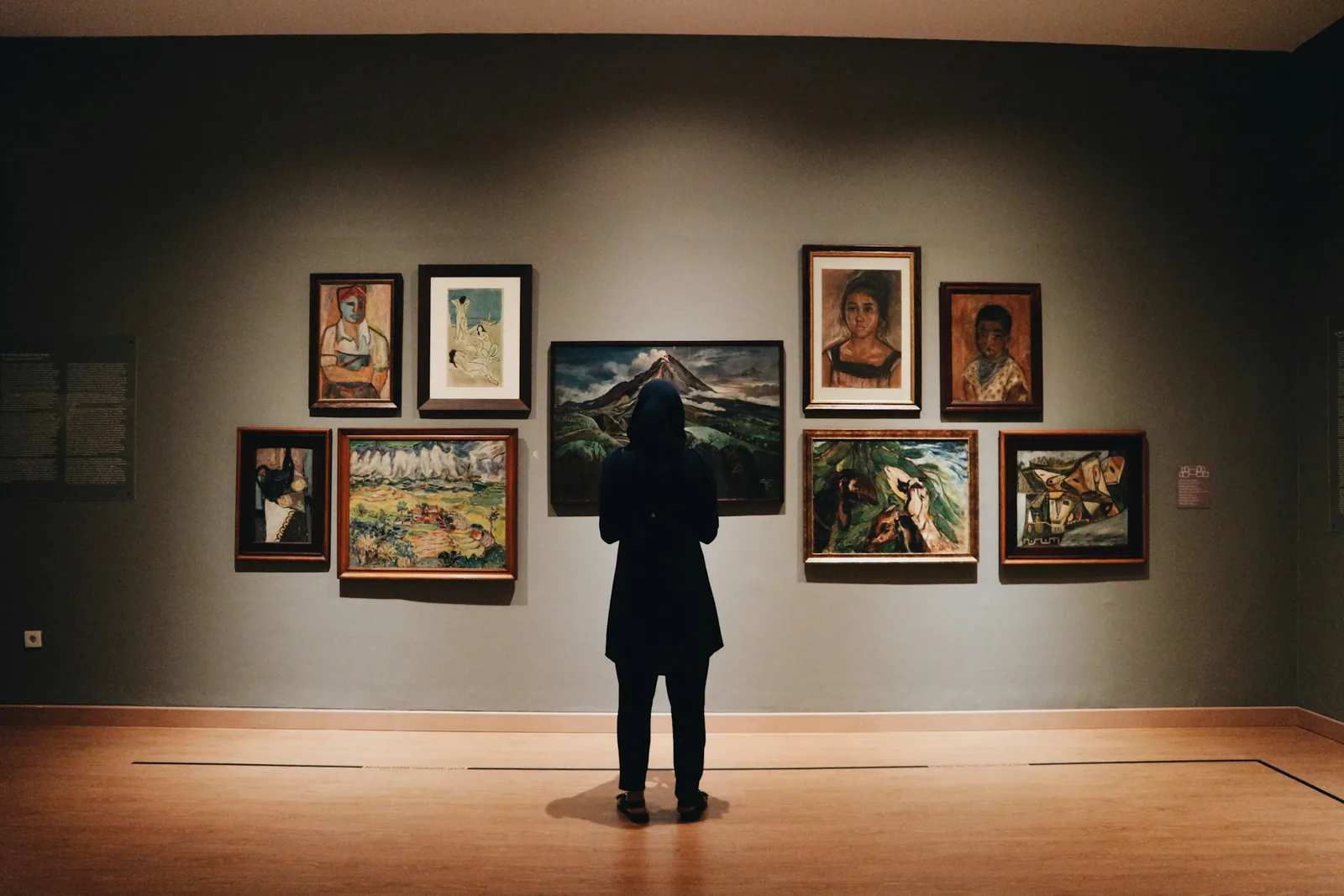 A visitor looking at paintings in a gallery