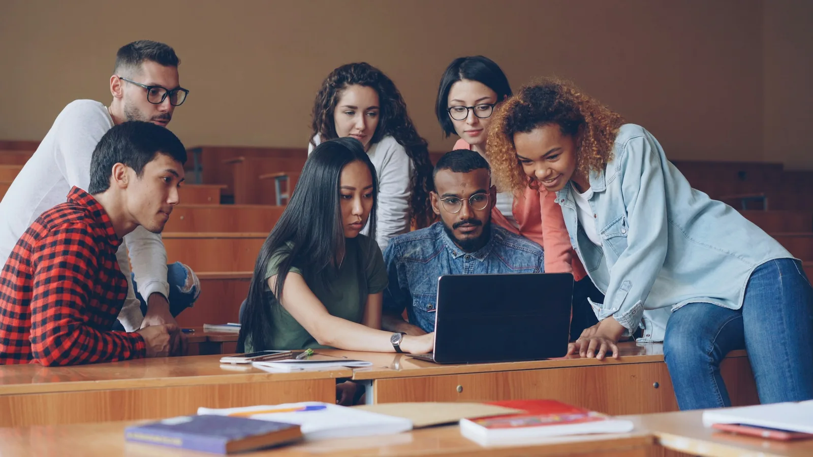 Students gathered around a laptop